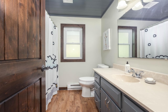 2510 Conifer Ave, Alexandria, MN 56308 - bathroom featuring a baseboard radiator, wood finished floors, toilet, vanity, and plenty of natural light