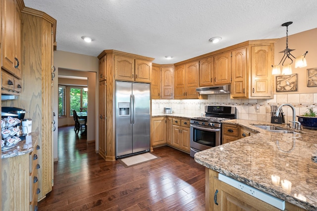14573 Krypton St NW, Ramsey, MN 55303 - kitchen with appliances with stainless steel finishes, a sink, under cabinet range hood, light stone counters, and dark wood finished floors