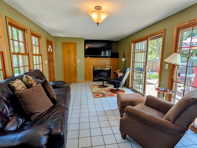 617 9th St, Montevideo, MN 56265 - living area featuring light tile patterned floors, a glass covered fireplace, and a textured ceiling