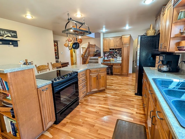 617 9th St, Montevideo, MN 56265 - kitchen with open shelves, electric range, light wood-style floors, a sink, and a kitchen island