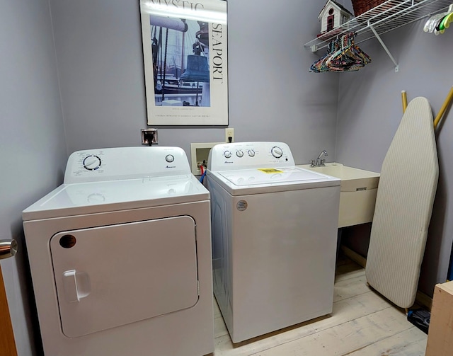 617 9th St, Montevideo, MN 56265 - clothes washing area featuring washing machine and dryer and light wood-style floors