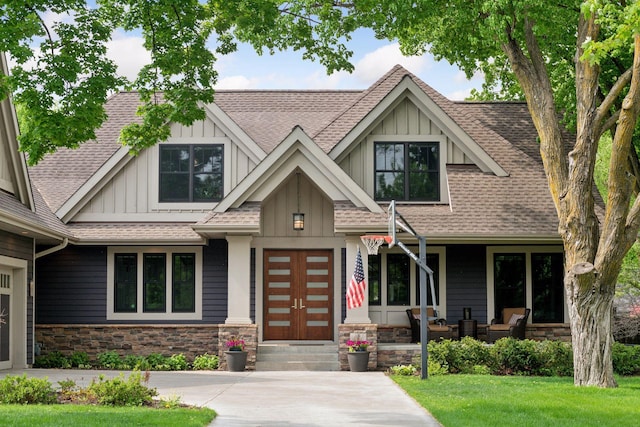 154 Babcock Ln, Wayzata, MN 55391 - craftsman-style house featuring board and batten siding, a shingled roof, stone siding, and a front lawn