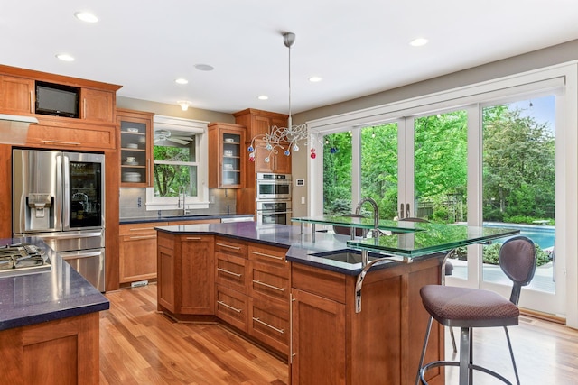 154 Babcock Ln, Wayzata, MN 55391 - kitchen featuring stainless steel appliances, a sink, healthy amount of natural light, brown cabinetry, and recessed lighting