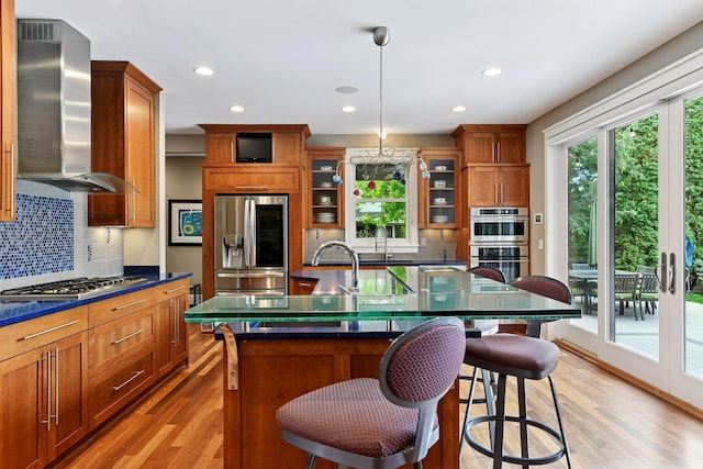 154 Babcock Ln, Wayzata, MN 55391 - kitchen featuring appliances with stainless steel finishes, wall chimney exhaust hood, dark countertops, healthy amount of natural light, and recessed lighting