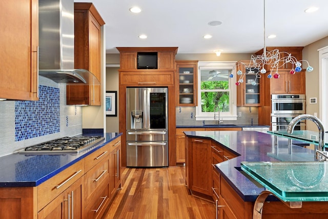 154 Babcock Ln, Wayzata, MN 55391 - kitchen featuring stainless steel appliances, wall chimney range hood, brown cabinets, light wood-type flooring, and a sink