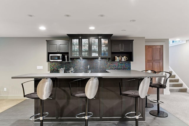 154 Babcock Ln, Wayzata, MN 55391 - bar featuring stainless steel microwave, decorative backsplash, baseboards, stairway, and recessed lighting
