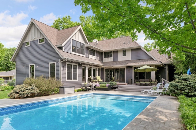 154 Babcock Ln, Wayzata, MN 55391 - back of property with roof with shingles, a patio area, an outdoor pool, outdoor dining area, and board and batten siding