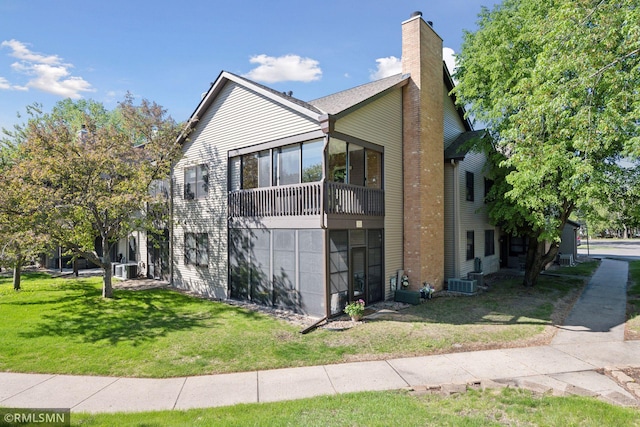 11031 Oregon Cir Unit 58, Bloomington, MN 55438 - view of side of property with a yard, central air condition unit, a chimney, and a sunroom