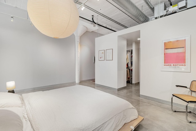 730 Stinson Blvd Unit 406, Minneapolis, MN 55413 - bedroom with concrete floors, baseboards, a walk in closet, a closet, and a high ceiling