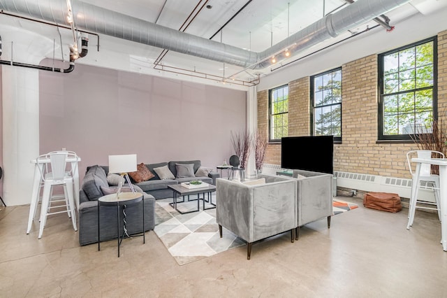 730 Stinson Blvd Unit 406, Minneapolis, MN 55413 - living area featuring brick wall, concrete floors, and a high ceiling