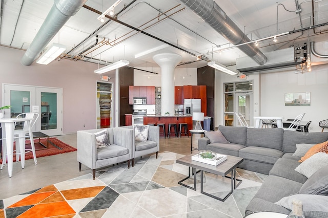 730 Stinson Blvd Unit 406, Minneapolis, MN 55413 - living area featuring french doors, a towering ceiling, and finished concrete flooring