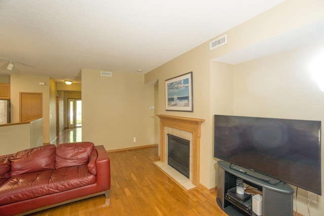 1675 Skywood Ln, Eagan, MN 55122 - living room with light wood-style floors, a tile fireplace, baseboards, and rail lighting