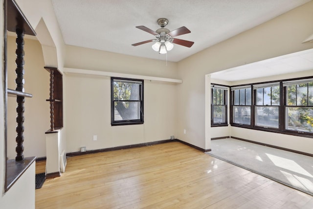1264 Snelling Ave N, Saint Paul, MN 55108 - spare room featuring plenty of natural light, a ceiling fan, wood finished floors, and baseboards