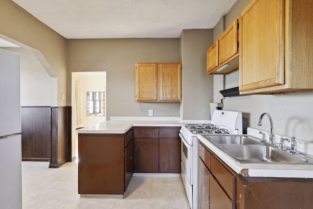 1264 Snelling Ave N, Saint Paul, MN 55108 - kitchen with white appliances, a sink, light countertops, and a peninsula