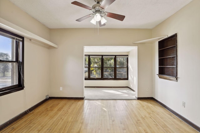 1264 Snelling Ave N, Saint Paul, MN 55108 - spare room with wood-type flooring, ceiling fan, baseboards, and a textured ceiling