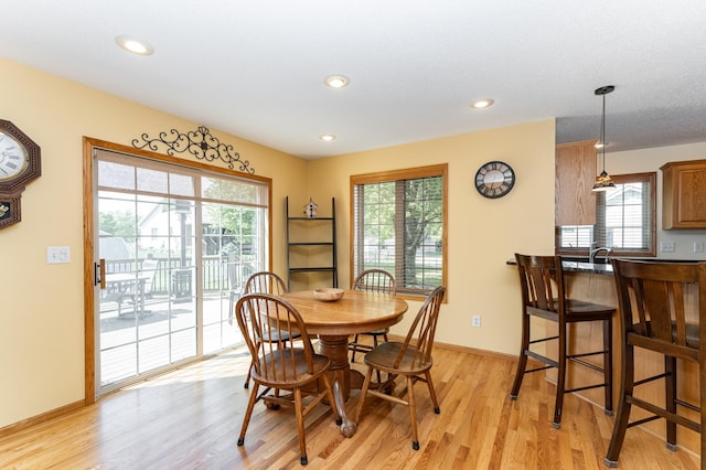 dining area featuring light wood finished floors, healthy amount of natural light, recessed lighting, and baseboards