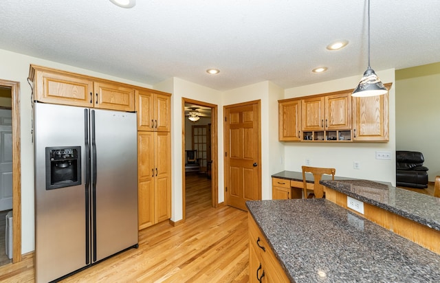 kitchen featuring stainless steel fridge with ice dispenser, light wood-style floors, decorative light fixtures, recessed lighting, and dark stone countertops