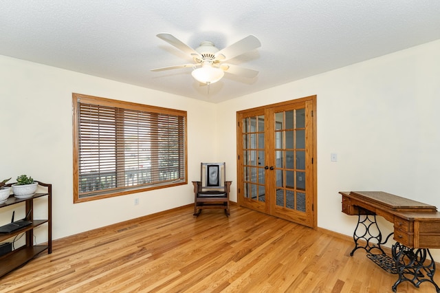 sitting room with light wood finished floors, ceiling fan, and baseboards