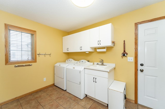washroom featuring cabinet space, washing machine and dryer, baseboards, and light tile patterned floors