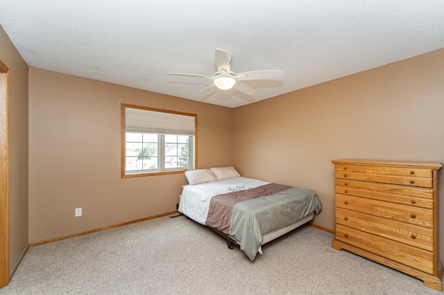 bedroom featuring light carpet, baseboards, and a ceiling fan