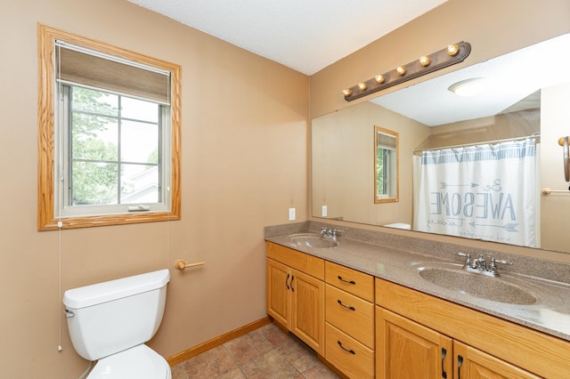 bathroom featuring toilet, double vanity, baseboards, and a shower with shower curtain