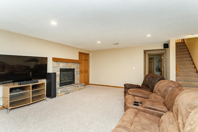 living room featuring light colored carpet, stairway, recessed lighting, a stone fireplace, and baseboards