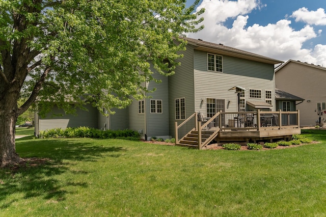 back of property featuring a wooden deck and a lawn