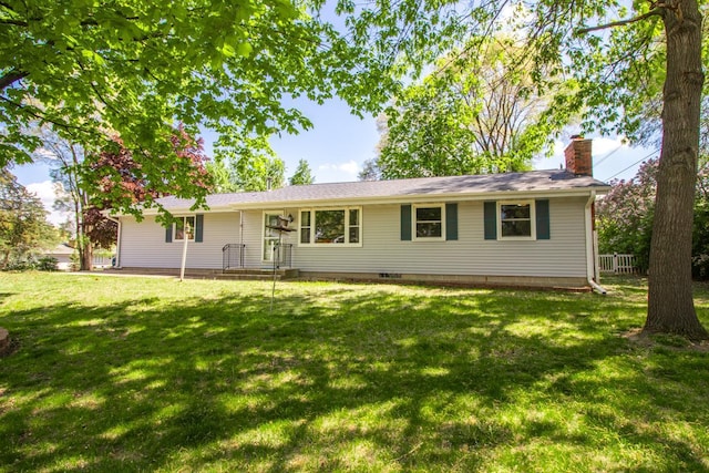 ranch-style house with a front yard and a chimney