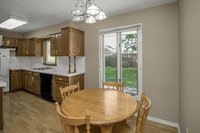 kitchen featuring dishwasher, freestanding refrigerator, a sink, light countertops, and light wood-type flooring