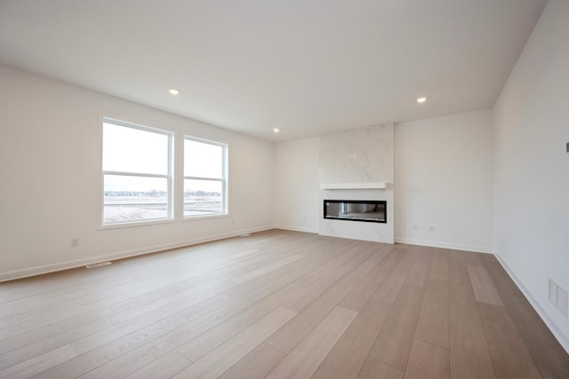 5713 Rathbun Way, Otsego, MN 55374 - unfurnished living room featuring wood finished floors, recessed lighting, a glass covered fireplace, baseboards, and built in shelves