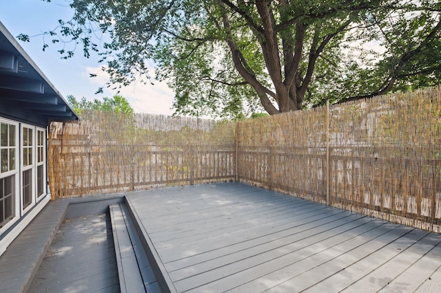 wooden deck with a fenced backyard