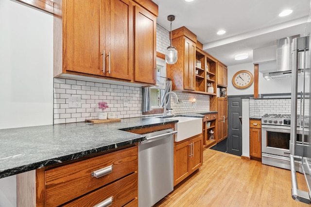 kitchen featuring open shelves, appliances with stainless steel finishes, brown cabinetry, wall chimney exhaust hood, and recessed lighting