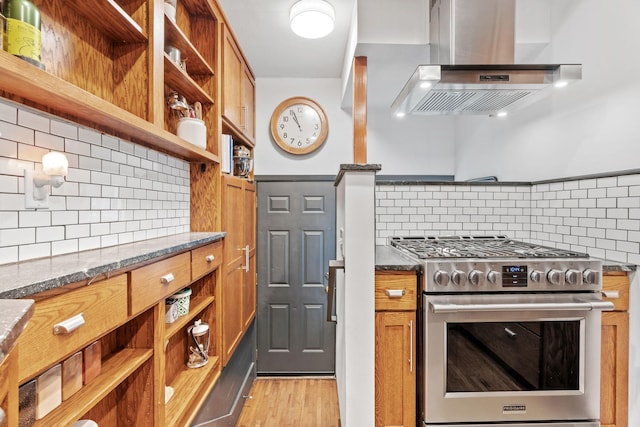 kitchen with gas range, open shelves, wall chimney exhaust hood, and backsplash