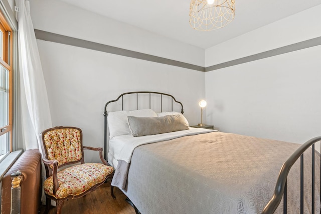bedroom with a chandelier and wood finished floors