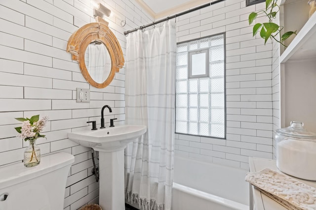 bathroom featuring tile walls, toilet, and shower / tub combo