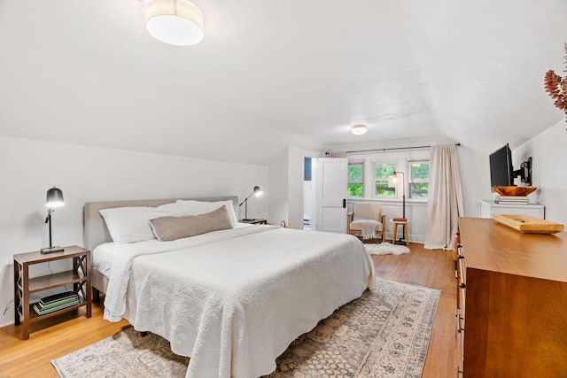 bedroom featuring light wood-type flooring and lofted ceiling