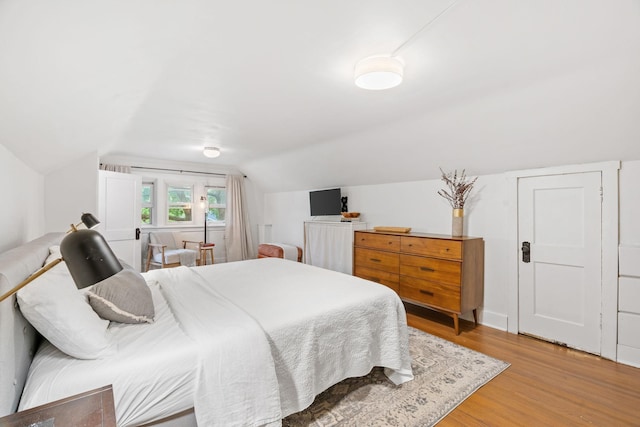 bedroom featuring light wood-style floors and lofted ceiling