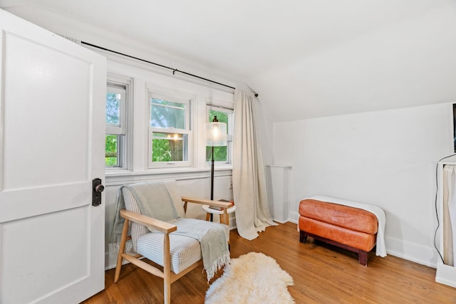 living area with lofted ceiling, wood finished floors, and baseboards