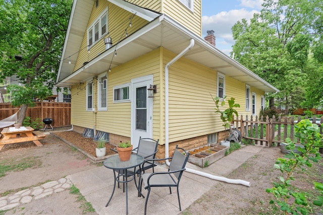 back of house featuring a patio and a chimney