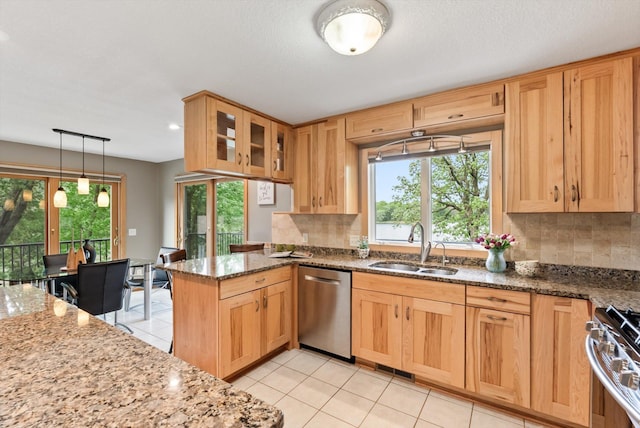 2270 Manning Trl N, Lake Elmo, MN 55042 - kitchen with appliances with stainless steel finishes, a sink, stone countertops, and tasteful backsplash