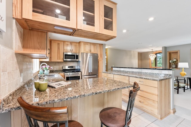 2270 Manning Trl N, Lake Elmo, MN 55042 - kitchen featuring stainless steel appliances, a sink, a peninsula, light brown cabinetry, and light stone countertops