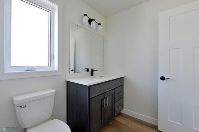 1182 Jill Dr W, West Fargo, ND 58078 - bathroom featuring vanity, wood finished floors, toilet, and baseboards