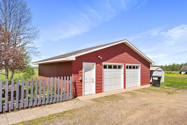 detached garage featuring fence