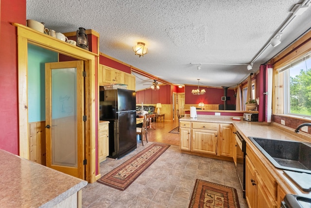 kitchen with freestanding refrigerator, a sink, track lighting, a peninsula, and dishwashing machine