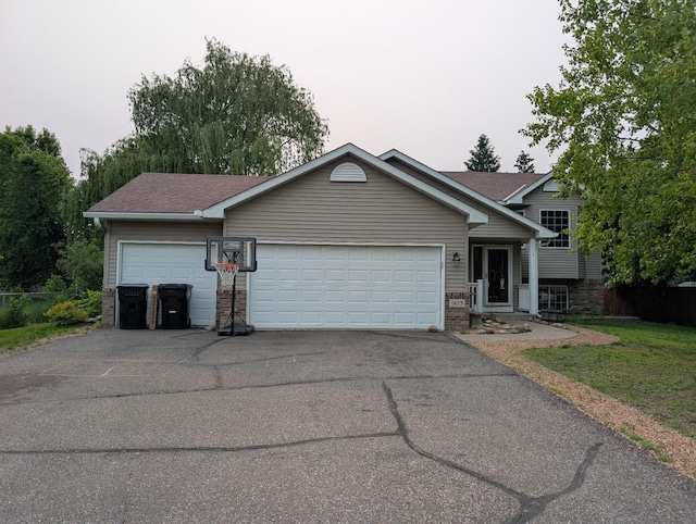 903 3rd Ave SW, Isanti, MN 55040 - tri-level home with asphalt driveway, an attached garage, brick siding, and a shingled roof