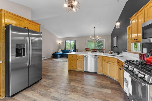 903 3rd Ave SW, Isanti, MN 55040 - kitchen with stainless steel appliances, vaulted ceiling, a sink, a chandelier, and a peninsula