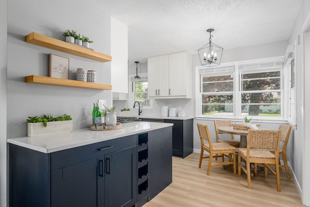 1805 Melrose Ave, Saint Louis Park, MN 55426 - kitchen with open shelves, light wood-type flooring, a chandelier, decorative light fixtures, and a textured ceiling