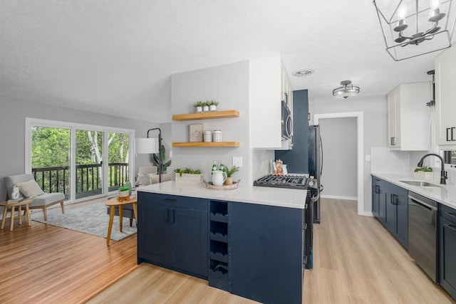 1805 Melrose Ave, Saint Louis Park, MN 55426 - kitchen featuring a sink, open shelves, stainless steel appliances, blue cabinets, and a textured ceiling