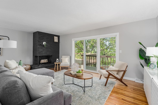 1805 Melrose Ave, Saint Louis Park, MN 55426 - living room featuring a brick fireplace, wood finished floors, and baseboards