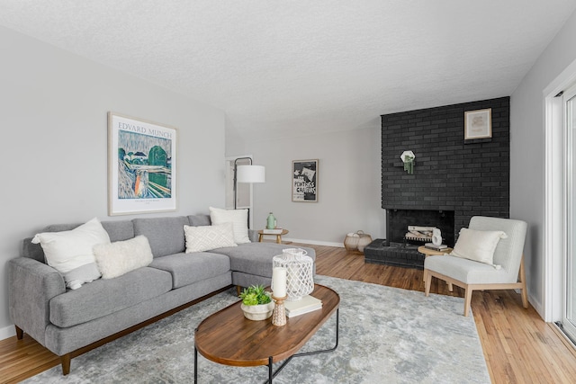 1805 Melrose Ave, Saint Louis Park, MN 55426 - living area featuring light wood-style flooring, a fireplace, a textured ceiling, and baseboards
